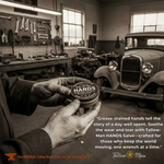 Grease-stained hands holding a Tallow Man Hand Salve tin in an automobile workshop, with promotional copy.