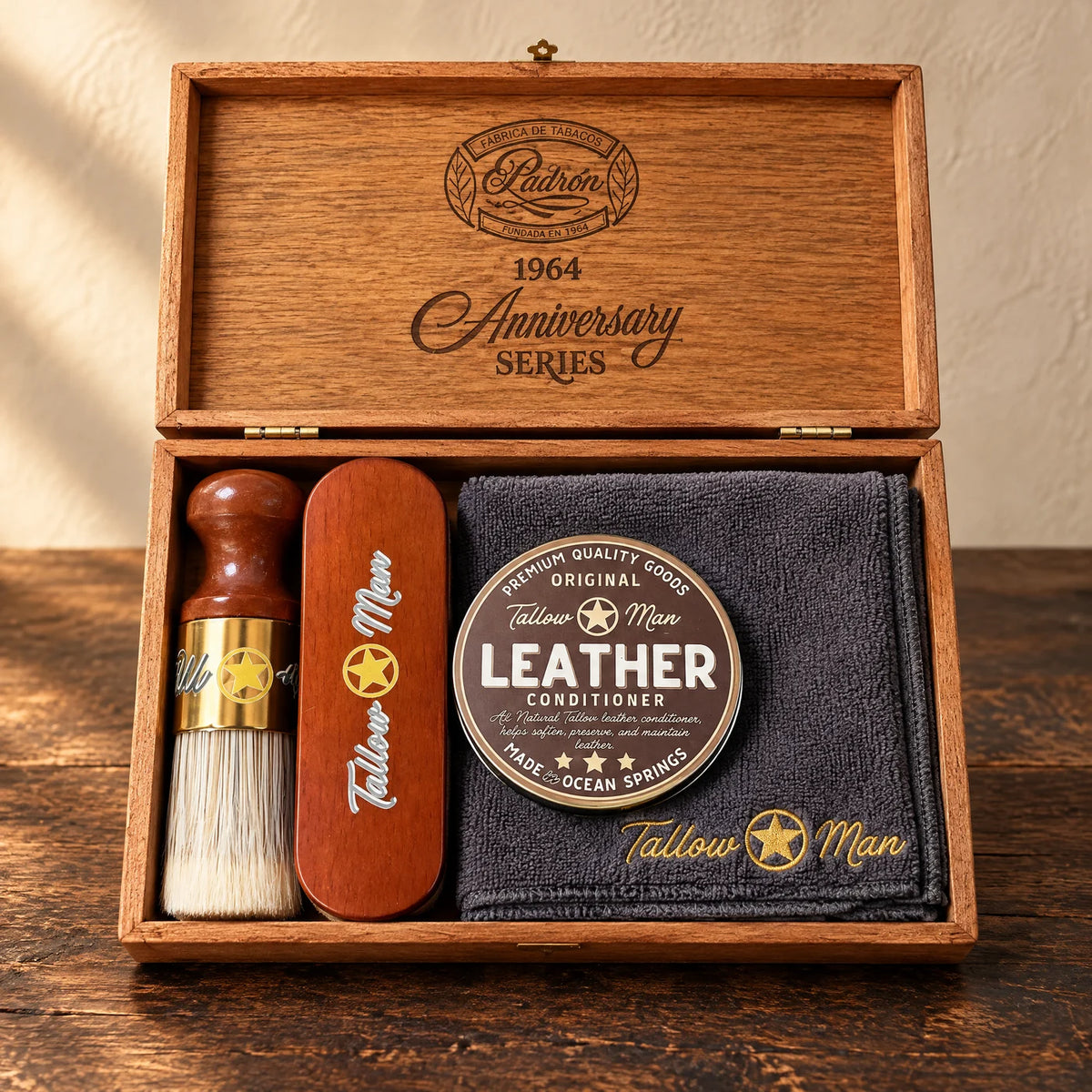 Tallow Man Deluxe Leather Kit with conditioner, two brushes and embroidered cloth in an open repurposed wood box.