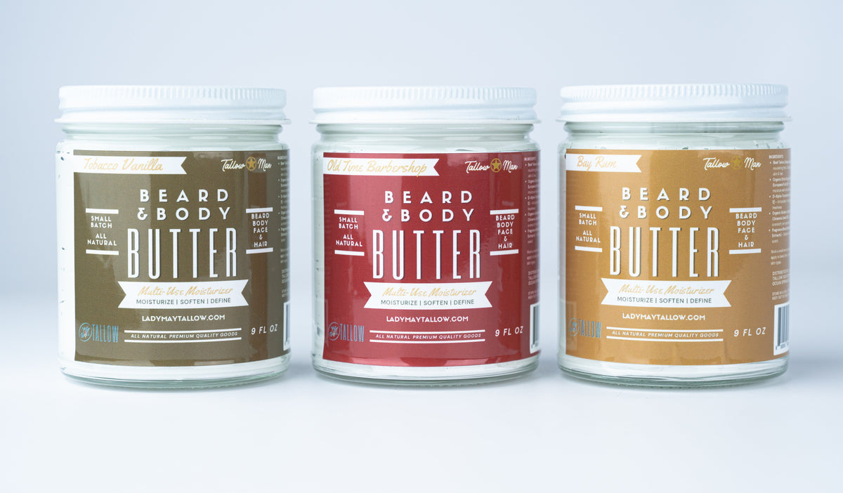 Three Tallow Man Beard + Body Butter jars: Tobacco Vanilla, Old Time Barbershop and Bay Rum, on a pale studio background.